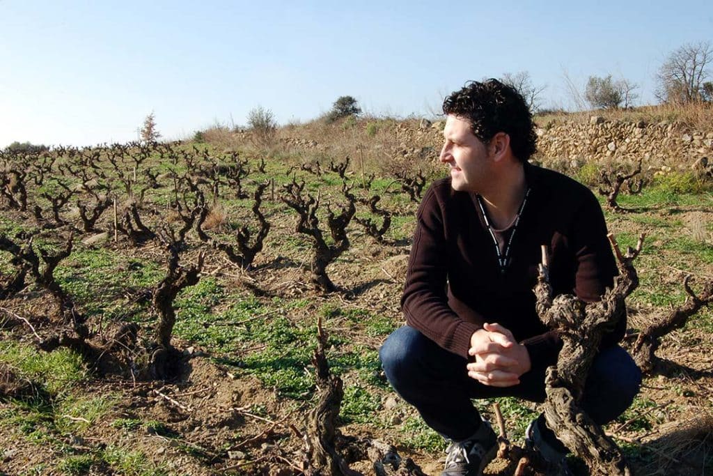 David Seijas sommelier en wijnmaker gehurkt in de wijngaard
