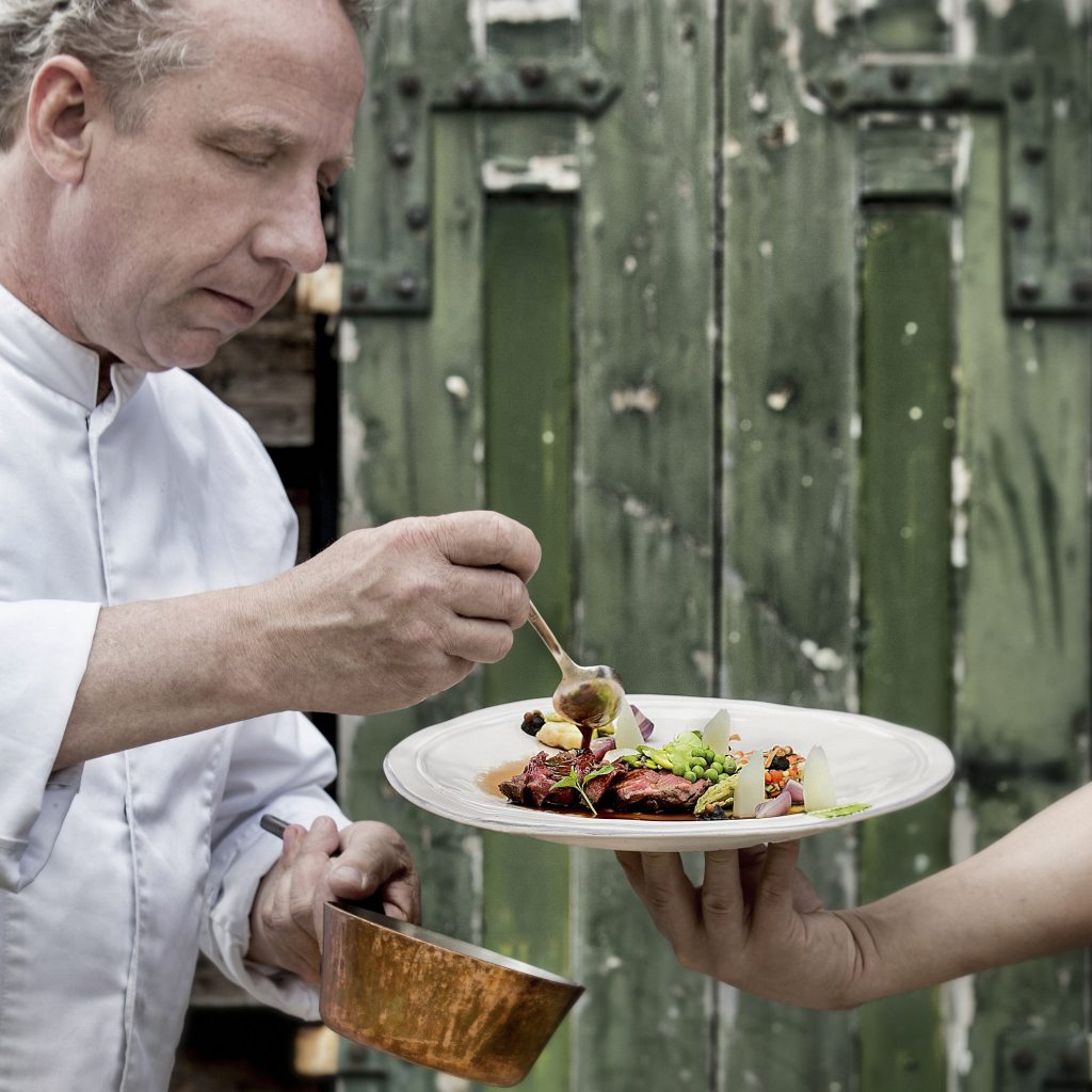 Rollade van damhert: Chef Nico Klaver van restaurant 't Kalkoentje tijdens het sauzen van de rollade