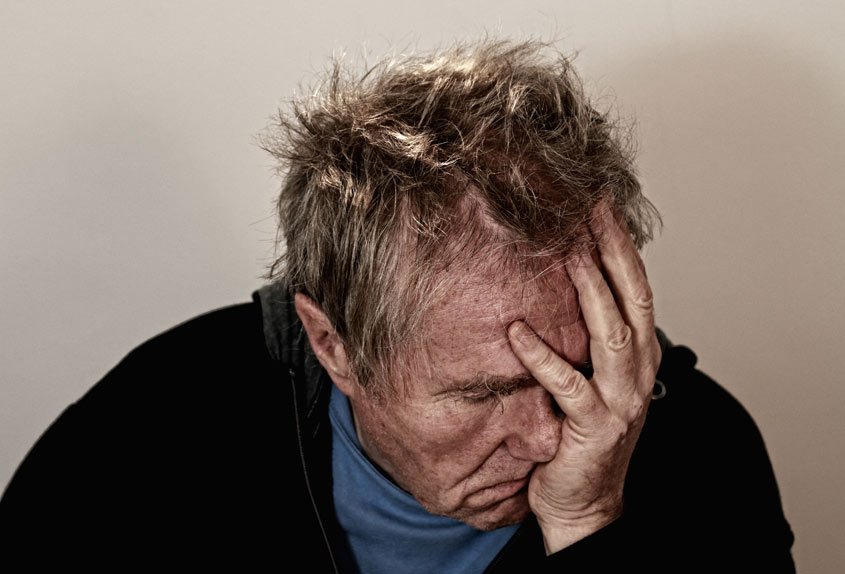 Hoofdpijn van wijn door sulfiet? De drietrapsraket die weinig mensen kennen. Over sulfiet, histamine en tyramine. Man die met zijn hoofd steunt op zijn hand.