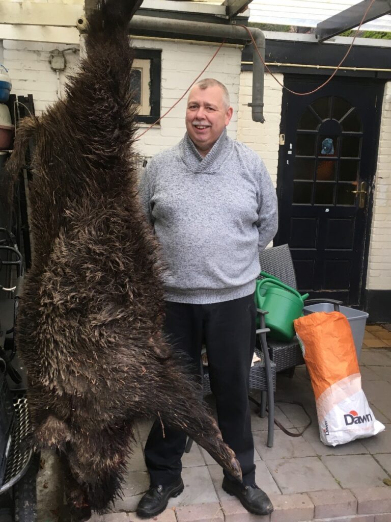 Jerry Overeem met een grote keiler die op zijn kop aan een haak hangt