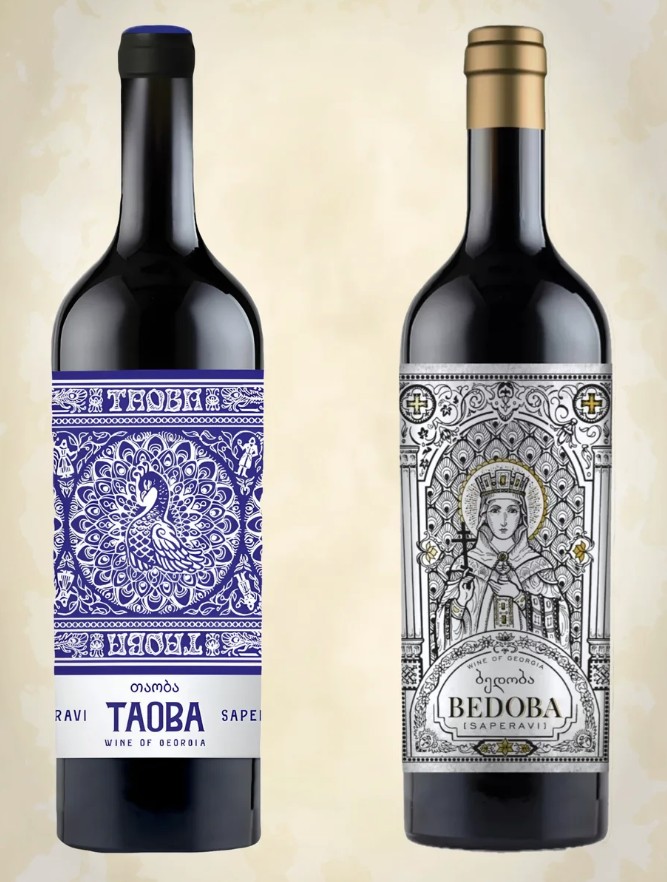 Links een fles Saperavi Taoba. Op het blauwe etiket een grote pauw. Rechts een fles Bedoba Saperavi met een religieuze figuur, een vrouw met een kroon.